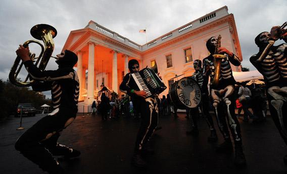 The White House is lit with orange light as a group of 'skeletons' perform.