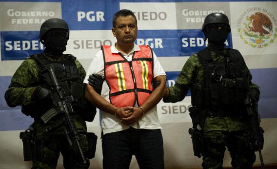 Soldiers of the Mexican Army escort Alfredo Aleman Narvaez, aka 'El Comandante Aleman', an alleged member of the drug cartel 'Los Zetas', during his presentation in Mexico City on November 17, 2011.