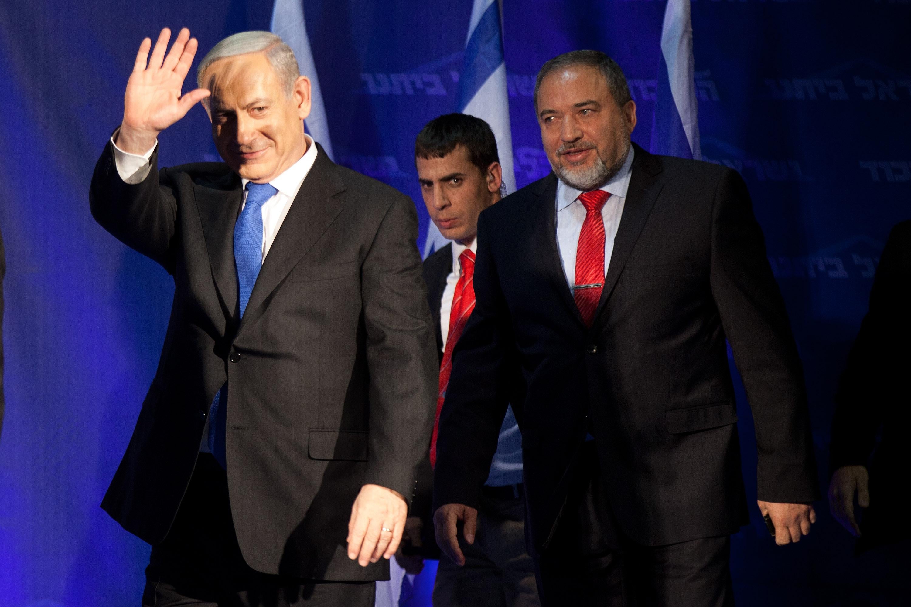  Israeli Prime Minister Benjamin Netanyahu waves to his supporters as he arrives with Former Israel Minister for Foreign Affairs Avigdor Liberman at his election campaign headquarters on Janurary 23, 2013 in Tel Aviv, Israel.