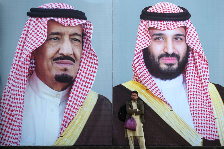 A man stands in front of billboards showing portraits of Saudi Arabian Crown Prince Mohammed bin Salman and his father and Saudi Arabia's King Salman bin Abdulaziz displayed on a street ahead of the prince's arrival in Islamabad on February 15, 2019.