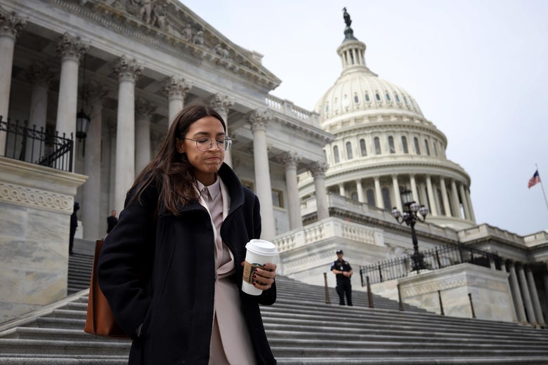 Ocasio-Cortez holds a coffee as she walks down the steps of the U.S. Capitol