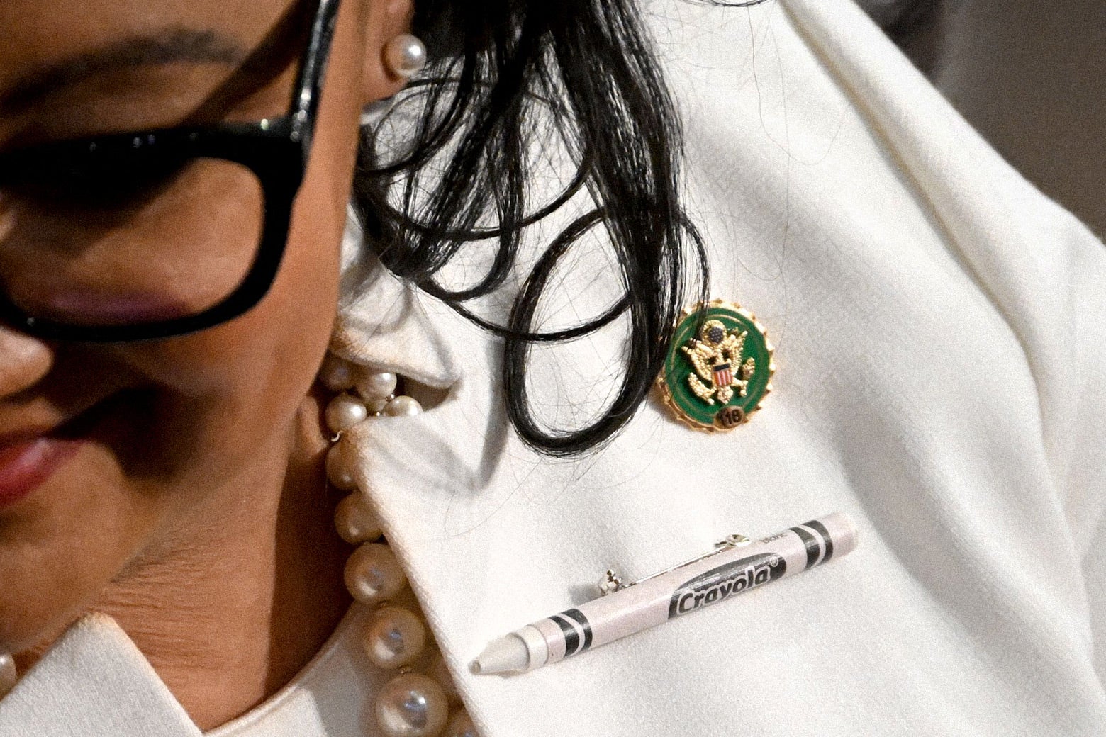 A close-up of a green pin for the 118th Congress on a lawmaker's lapel.