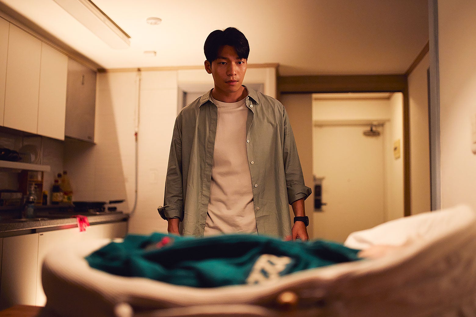 Jun-ho looking at the baby that has been placed in his apartment. why season 3 finale makes