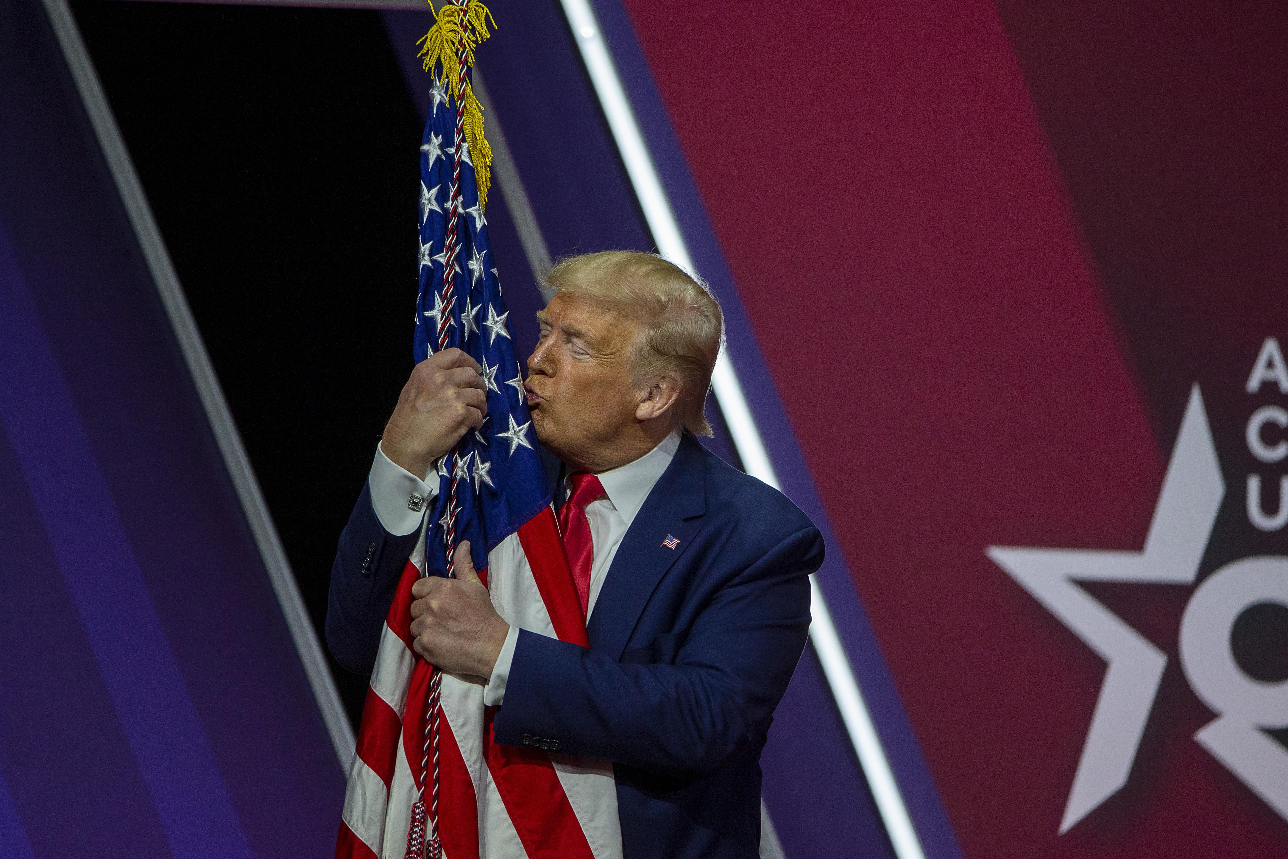 President Donald Trump kisses the flag of the United States of America at the annual Conservative Political Action Conference (CPAC) at Gaylord National Resort & Convention Center February 29, 2020 in National Harbor, Maryland.