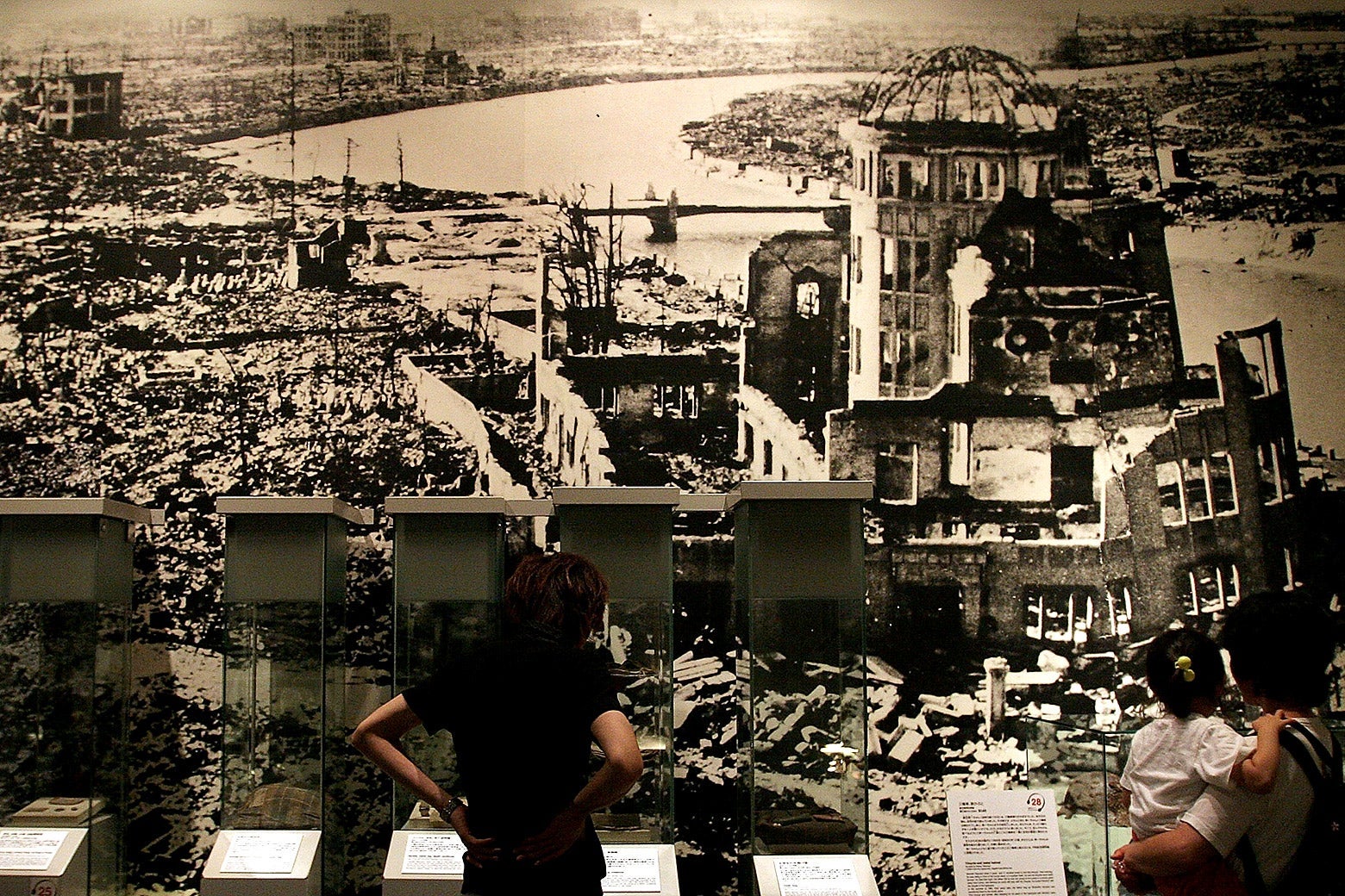 Visitors look at a picture, showing the aftermath of the atomic bomb attack on Hiroshima at the Hiroshima Peace Memorial Park in Japan.