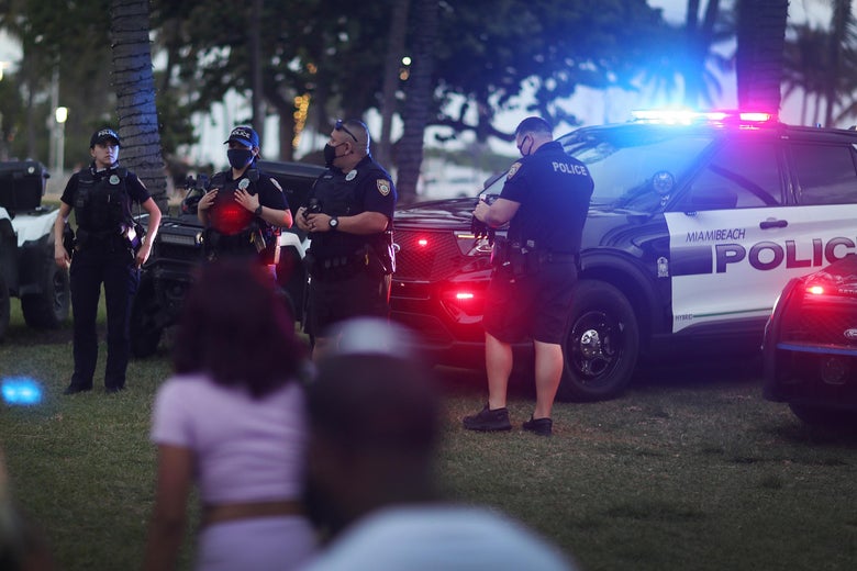 Miami Beach police officers keep an eye on people along Ocean Drive on March 19, 2021 in Miami Beach, Florida.