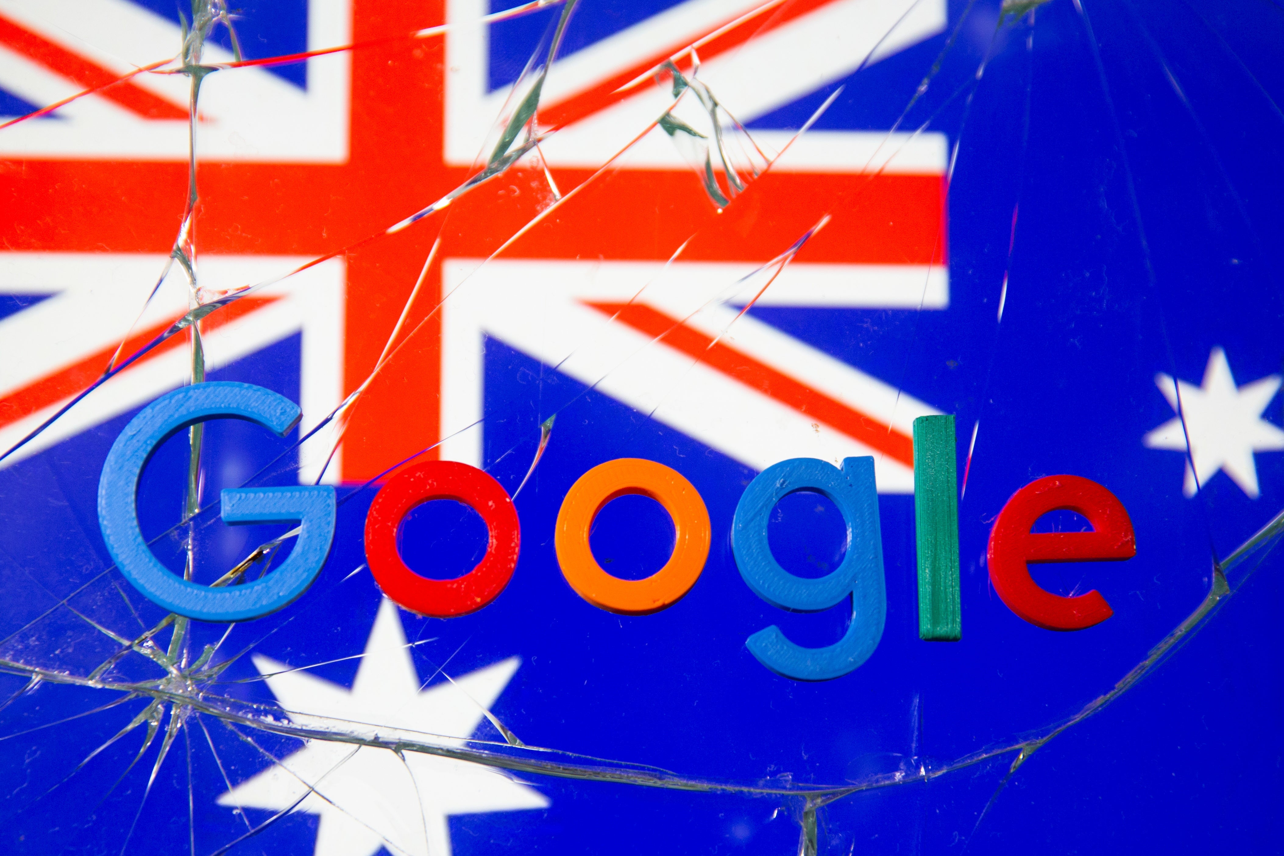 An Australian flag and the Google logo behind broken glass. 
