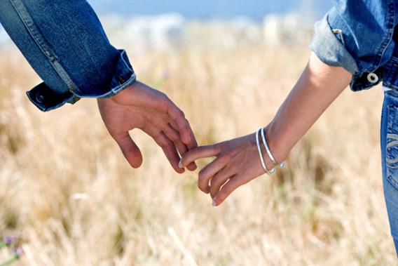 Couple holding hands outdoors.