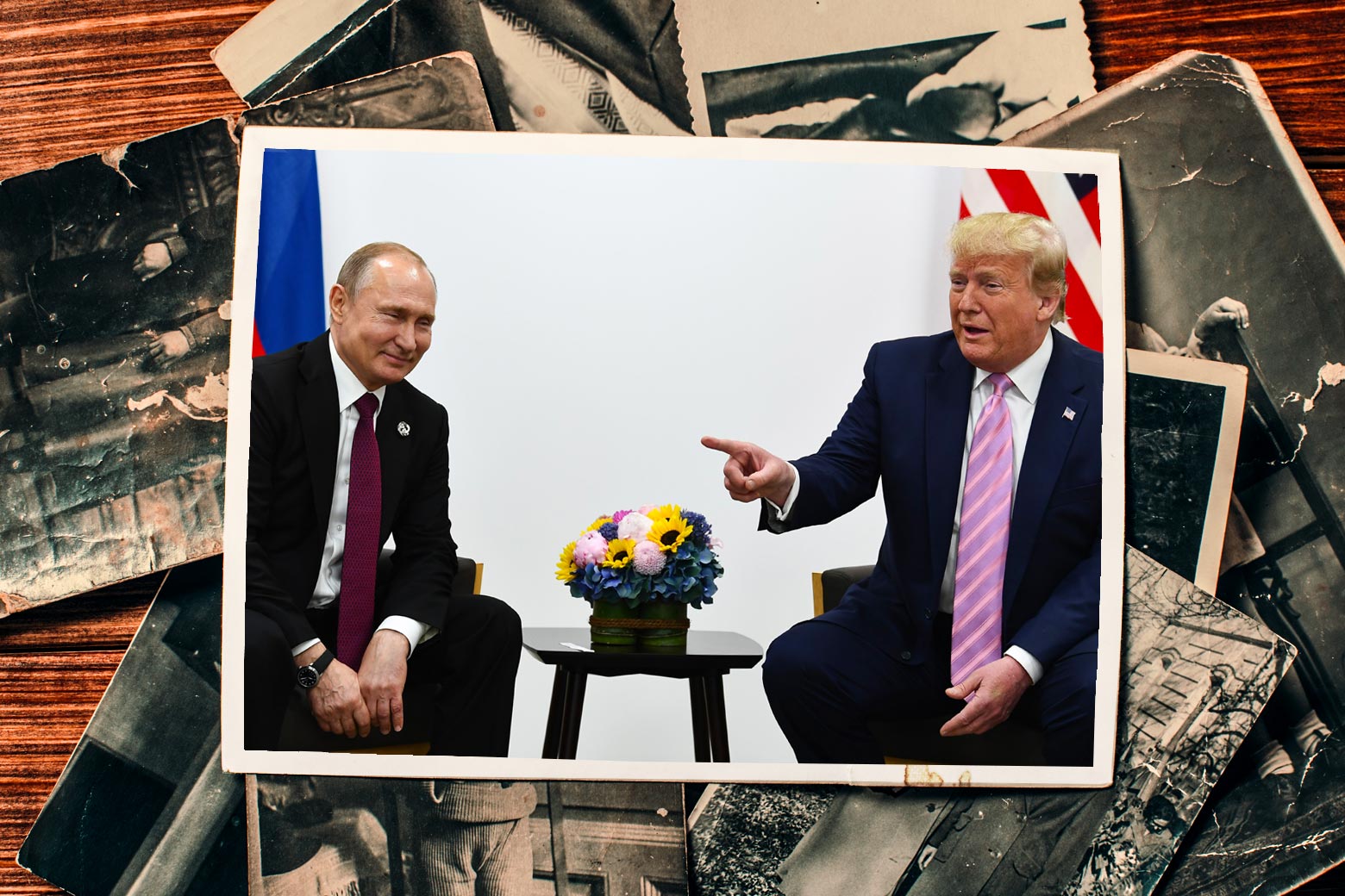 A photograph of Donald Trump meeting with Vladimir Putin on top of a pile of black-and-white photographs.