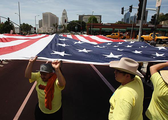 People carry a huge American flag in a march to the Metropolitan Detention Center during one a several May Day.