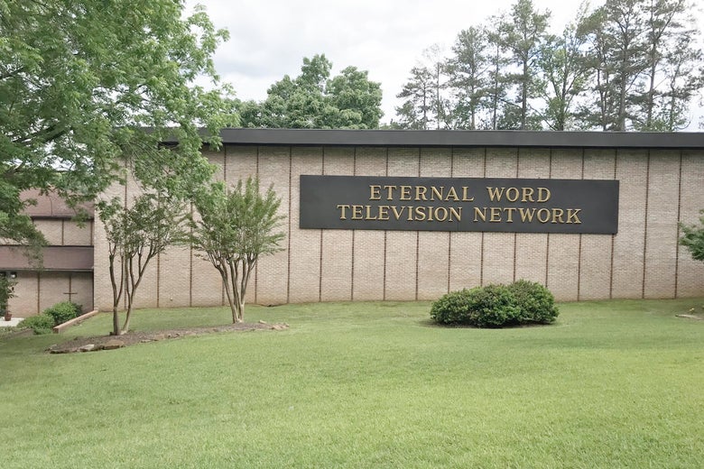 A sign that says "Eternal Word Television Network" on the exterior of a drab, low office building