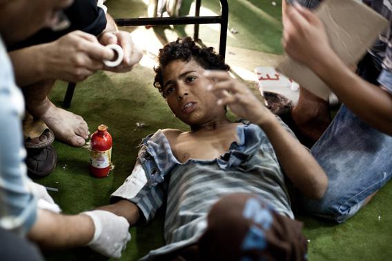 A wounded boy is treated as he lies on the floor of the Taamin Sehi field hospital during clashes between security officers and supporters of ousted president Mohamed Morsi, in downtown Cairo.