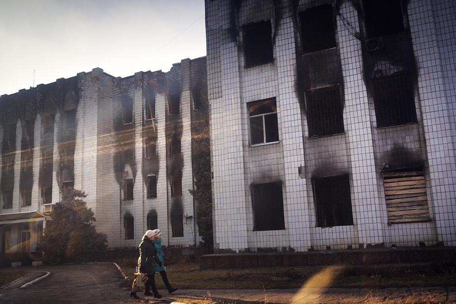 Two women pass the government building of Shakhtarsk, which was put on fire last spring.