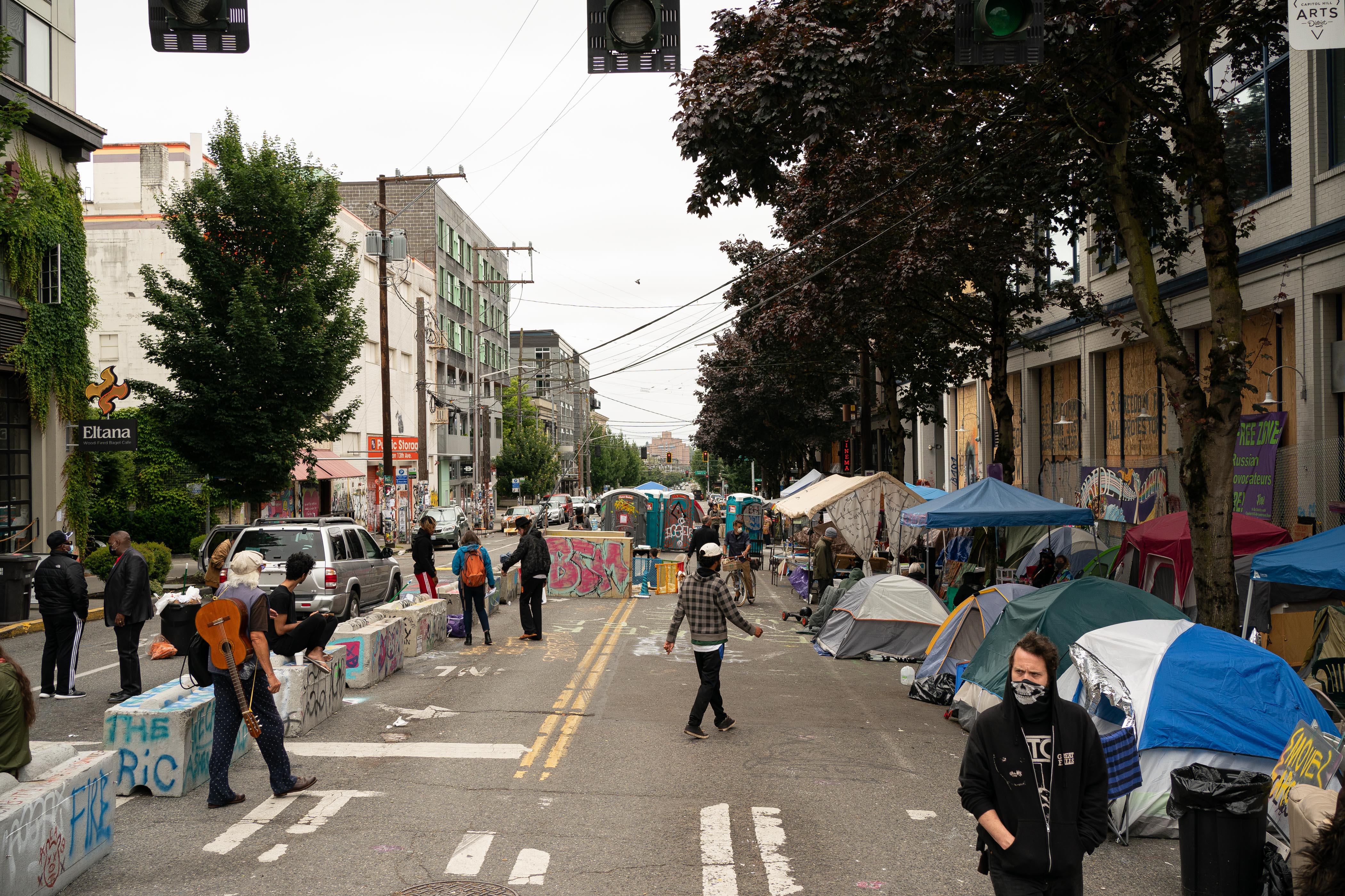People walk around a street lined with tents.