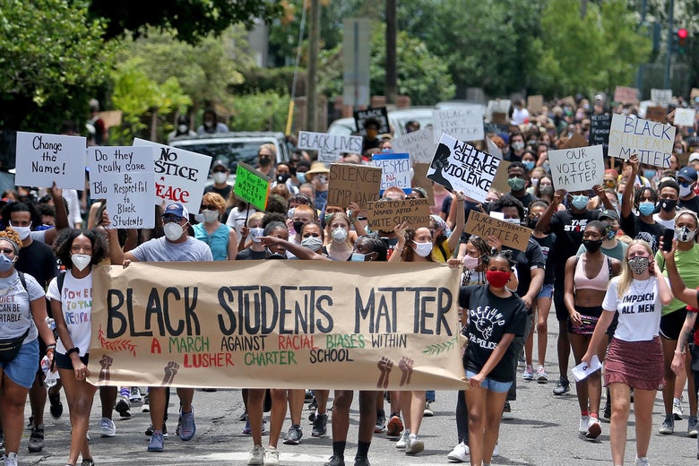 A large crowd of protesters with a sign in front that reads "Black Students Matter."
