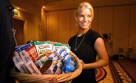 Pop star Jessica Simpson stands with a basket of tuna products during a visit to a Chicken of the Sea conference in 2003.