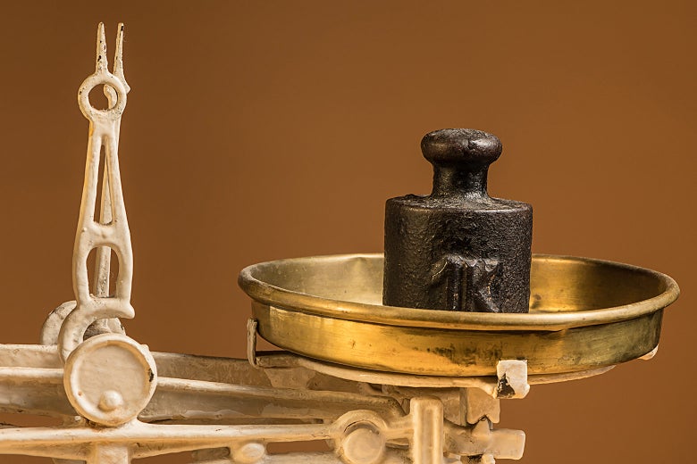A scale holding a one kilogram weight.