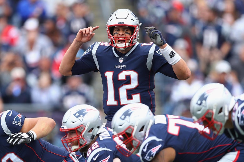 Tom Brady gestures at the line of scrimmage during an NFL game.