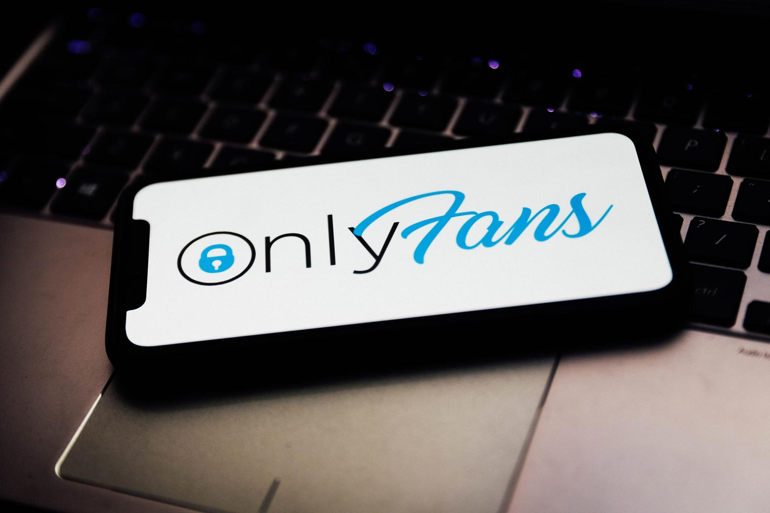 OnlyFans logo is seen displayed on a phone screen.