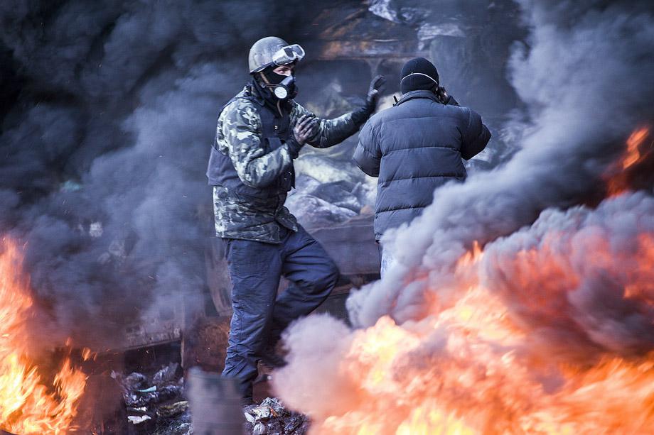 Demonstrators stand among the smoke of burning barricades during clashes with riot police in Kiev on Feb. 18, 2014. 