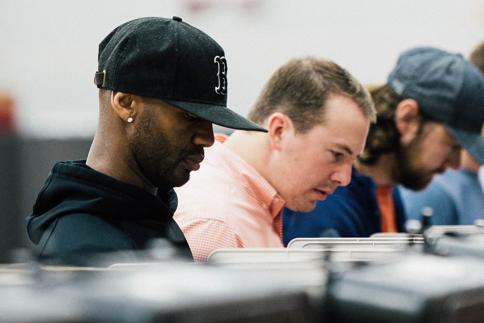A row of people using voting machines, with a black man in the foreground.