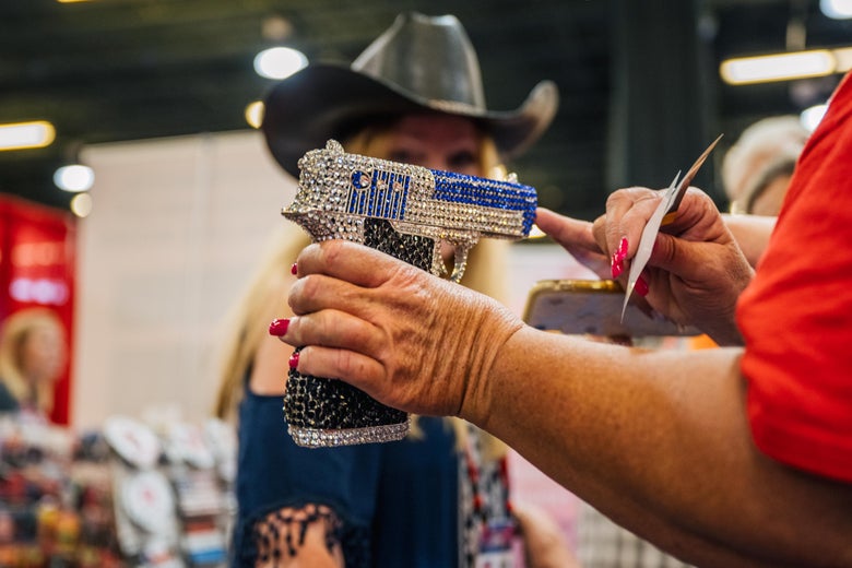 A woman explains handgun merchandise to a customer during the 2021 Conservative Political Action Conference CPAC in Dallas, Texas. 