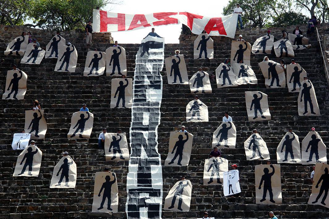 Activists of the Comuna organization hold painted silhouettes representing the 43 missing students, while performing a symbolic blockade of a pyramid at the archaeological site of Monte Alban in Oaxaca November 12, 2014.