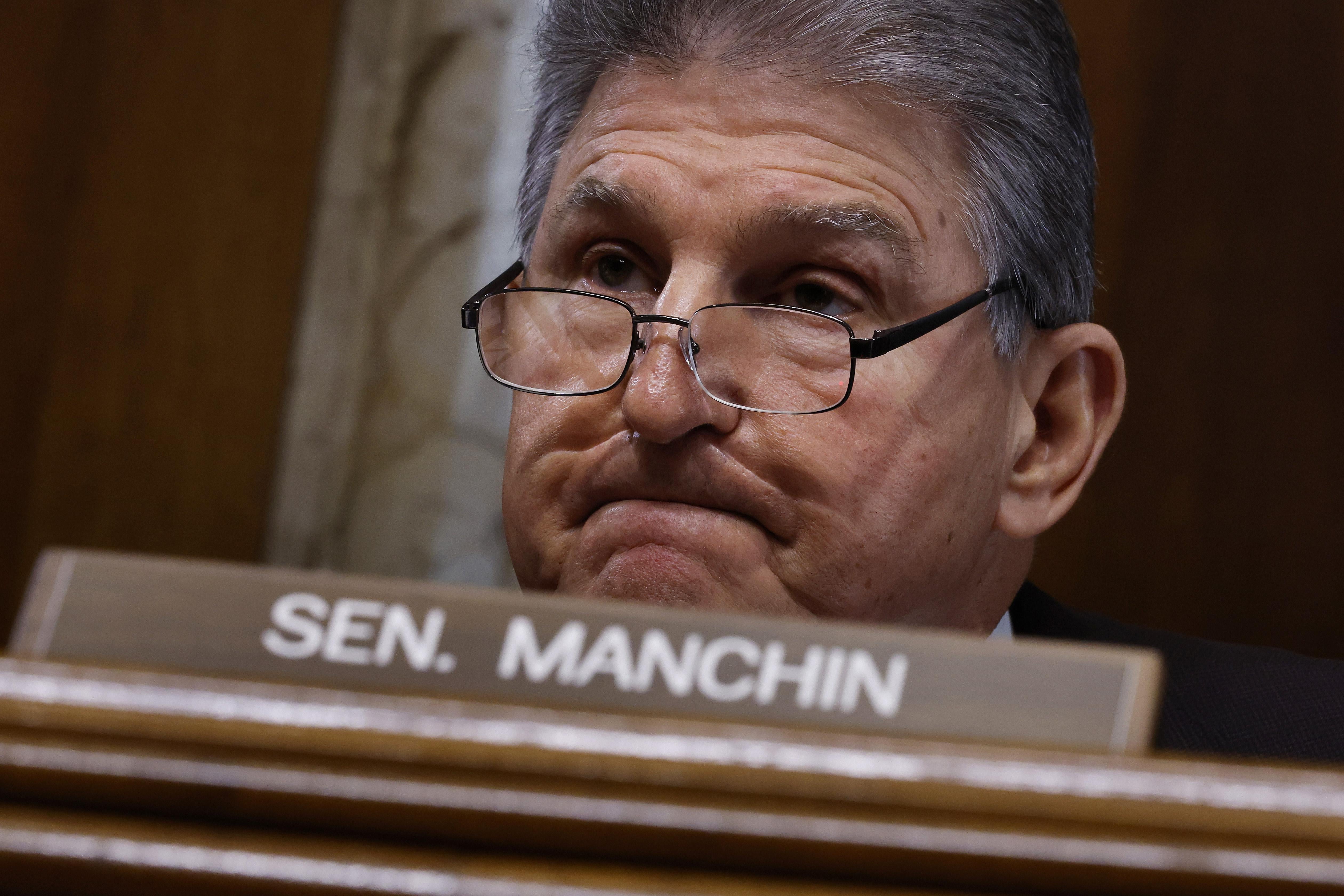Joe Manchin sitting in front of his placard in a hearing room