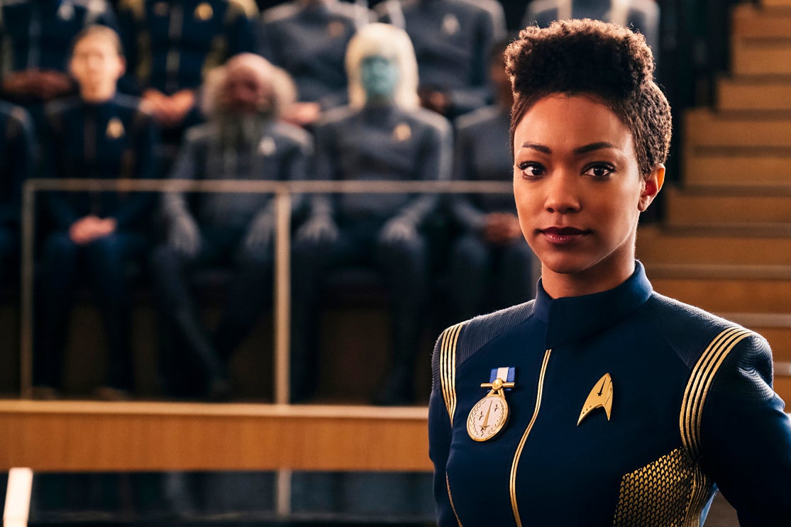 Sonequa Martin-Green as Michael Burnham wears a blue Starfleet uniform with a medal pinned on her chest