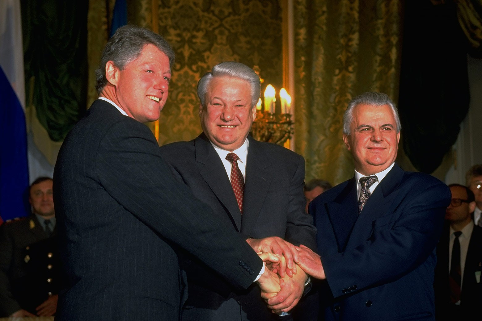 Three men in suits shaking hands.