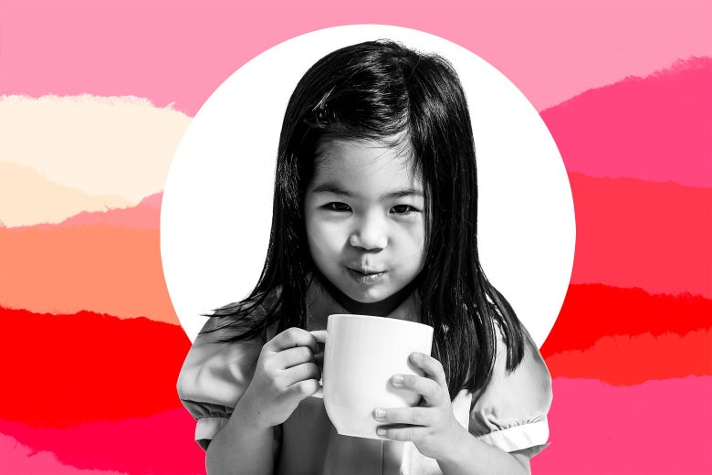 A little girl looking devious as she holds a mug