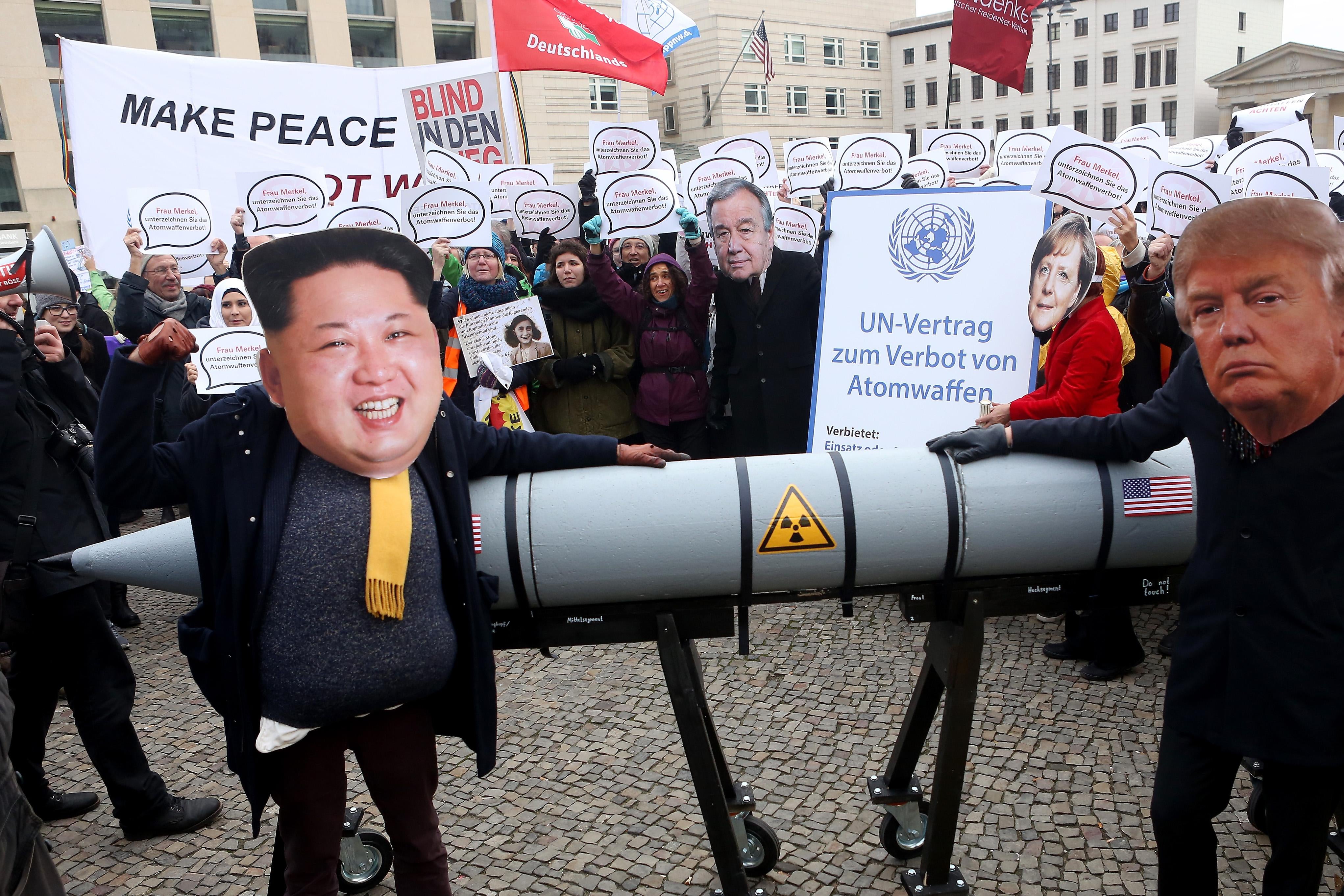BERLIN, GERMANY - NOVEMBER 18:  An activist with a mask of Kim Jong-un, chairman of the Workers' Party of Korea and supreme leader of North Korea (L), and another with a mask of U.S. President Donald Trump, march with a model of a nuclear rocket during a demonstration against nuclear weapons on November 18, 2017 in Berlin, Germany. About 700 demonstrators protested against the current escalation of threat of nuclear attack between the United States of America and North Korea. The event was organized by peace advocacy organizations including the International Campaign to Abolish Nuclear Weapons (ICAN), which won the Nobel Prize for Peace this year.  (Photo by Adam Berry/Getty Images)