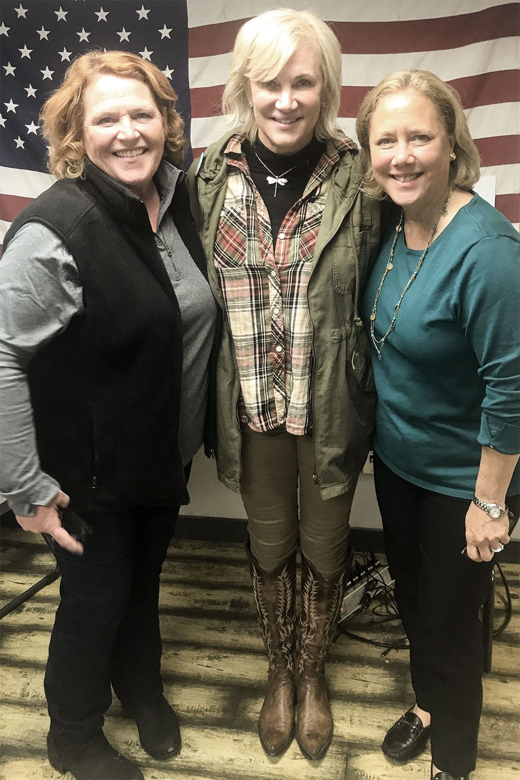 Sen. Heidi Heitkamp, the author, and former Sen. Mary Landrieu pose in front of an American flag.