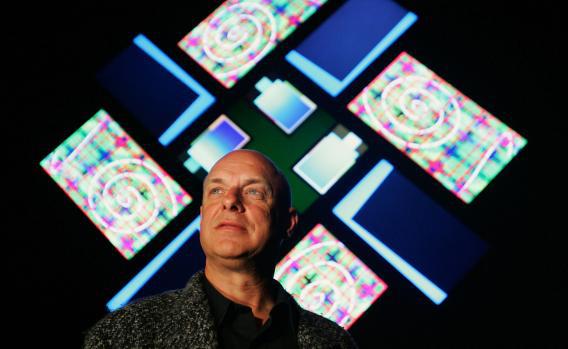 Artist and music producer Brian Eno poses in front of his latest light illustration.