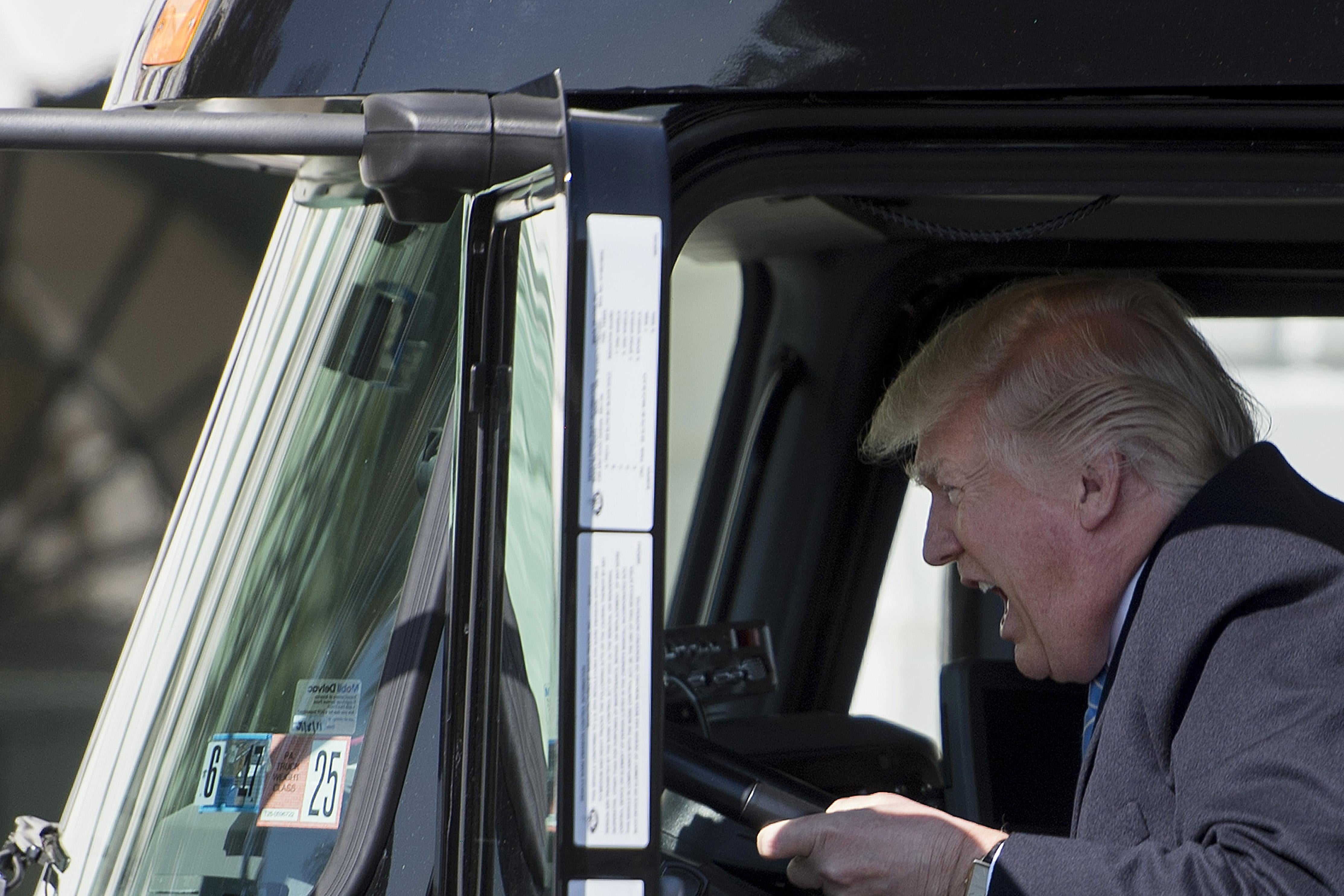 President Donald Trump sits in the drivers seat of a semi-truck like a big boy.