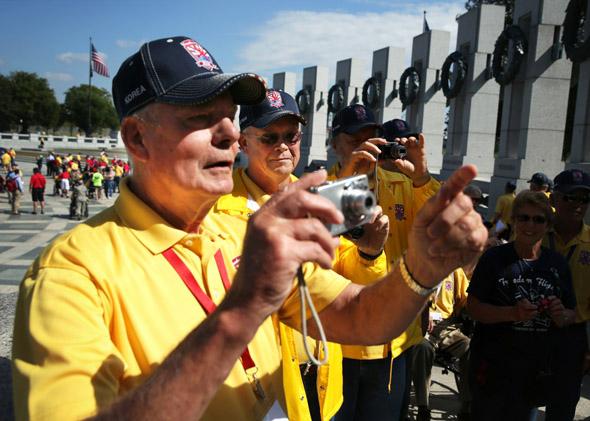 Korean War veteran Bill Bakley, Vietnam War veterans Norman Tjelmeland, and Stanley Twedt, of Ames, Iowa, snap pictures at the World War II Memorial after they were let in during a government shutdown.