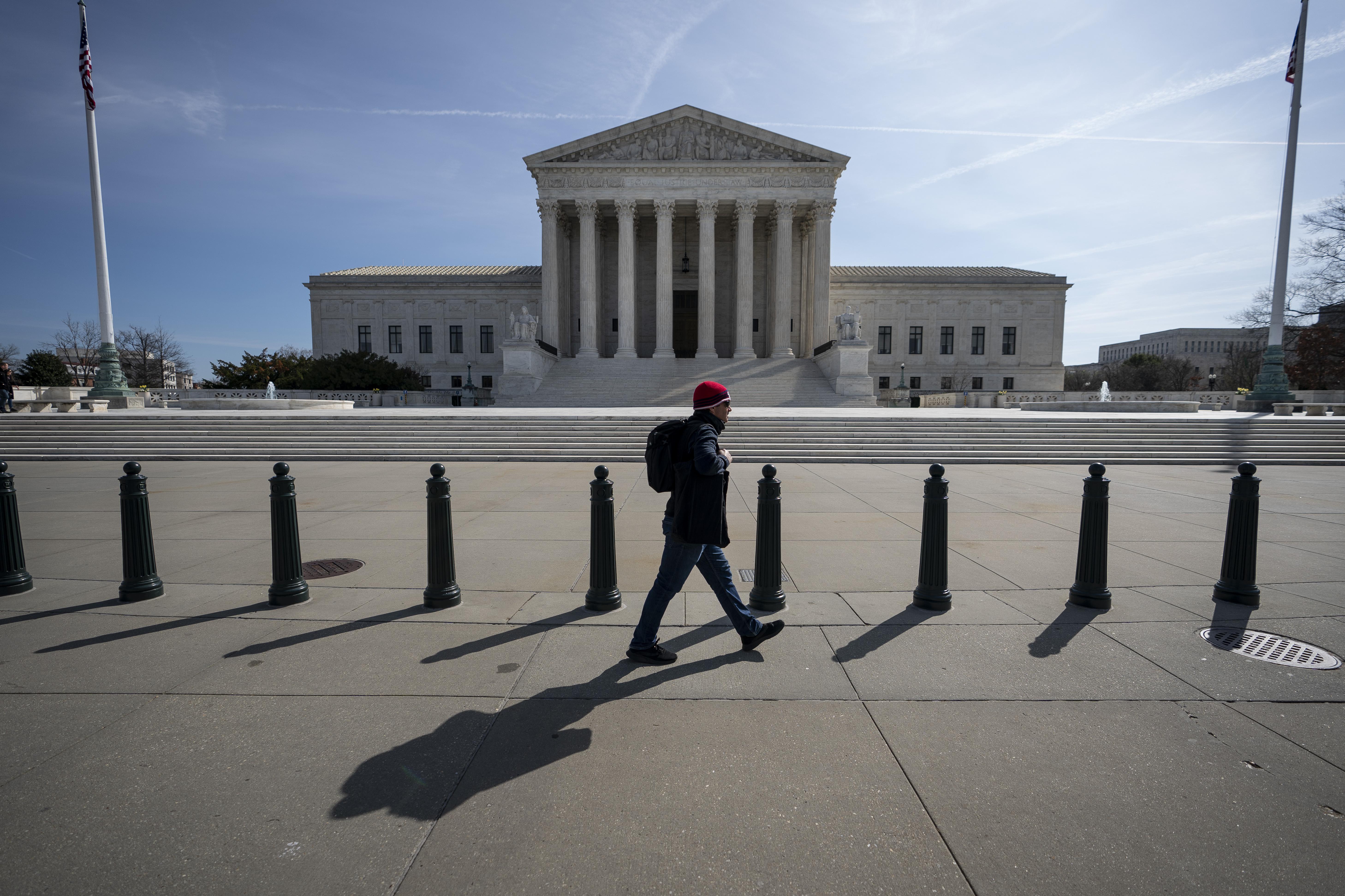 A man walks past the empty steps of the Supreme Court.