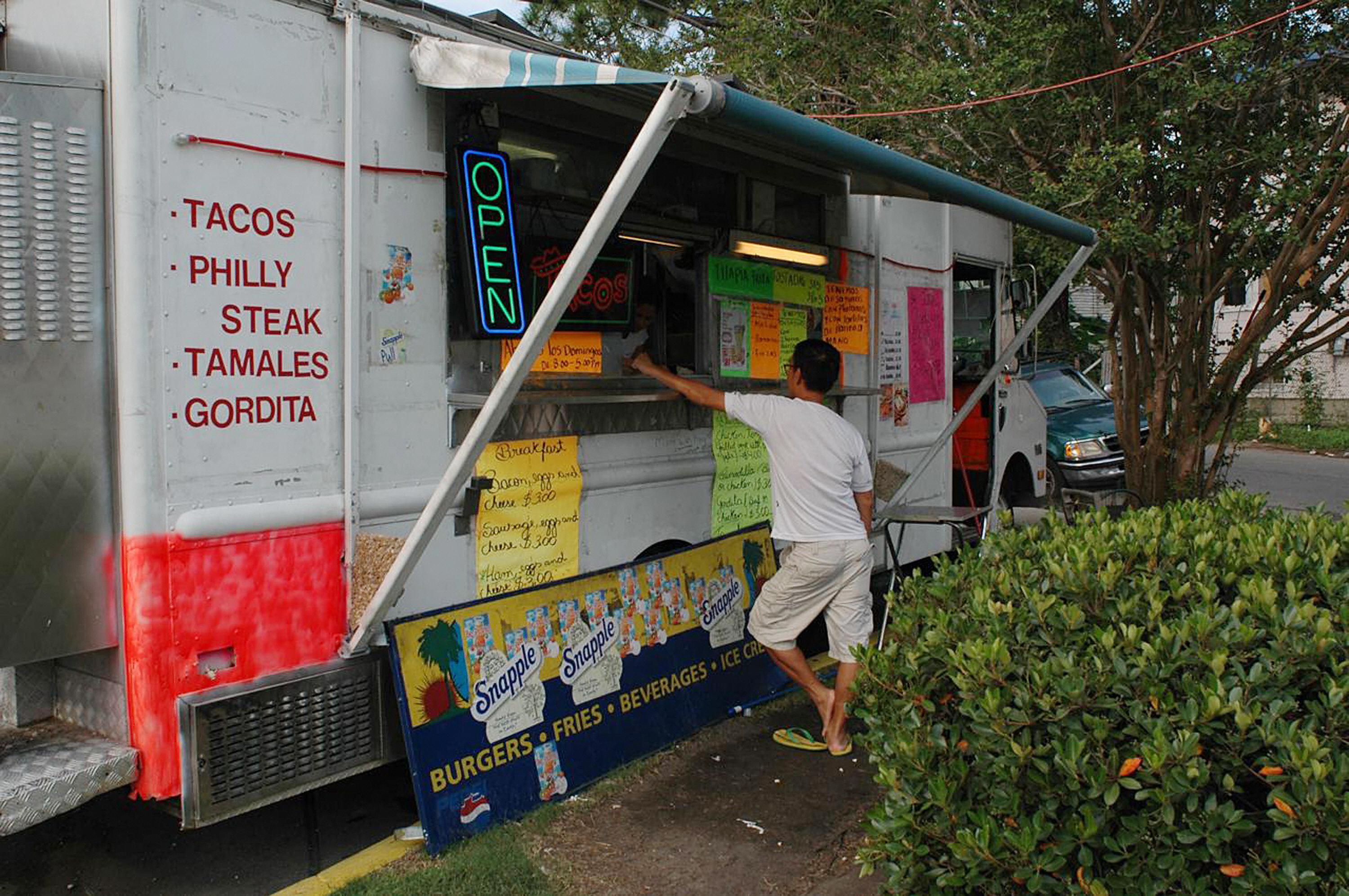 A customer buys food at a mobile Taqueria in New Orleans.