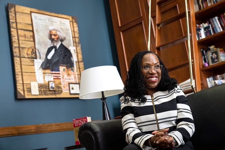 Ketanji Brown Jackson sits on a black couch in an office with a portrait of Frederick Douglass on the wall.