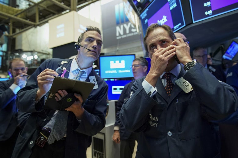 NEW YORK, NY - JUNE 20: Traders gather around a post as they wait for shares of Slack to start trading at the New York Stock Exchange (NYSE), June 20, 2019 in New York City. The workplace messaging app Slack will list on the New York Stock Exchange this morning. Shares of Slack were surging more than 60 percent over its reference price in early afternoon trading. (Photo by Drew Angerer/Getty Images)