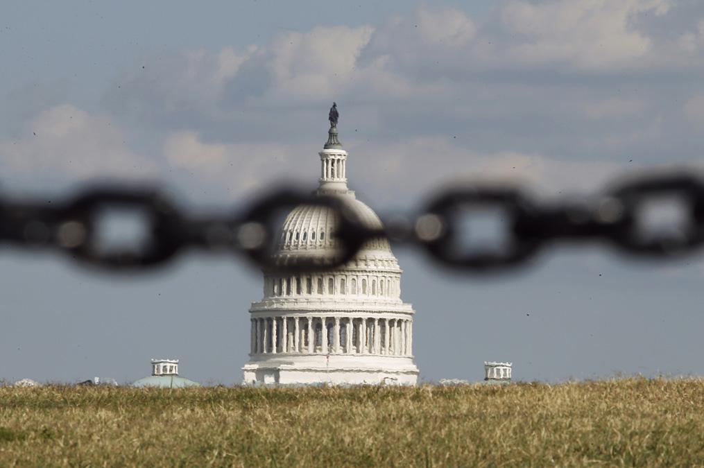 The U.S. Capitol is photographed through a chain fence in Washington, Sept. 30, 2013.