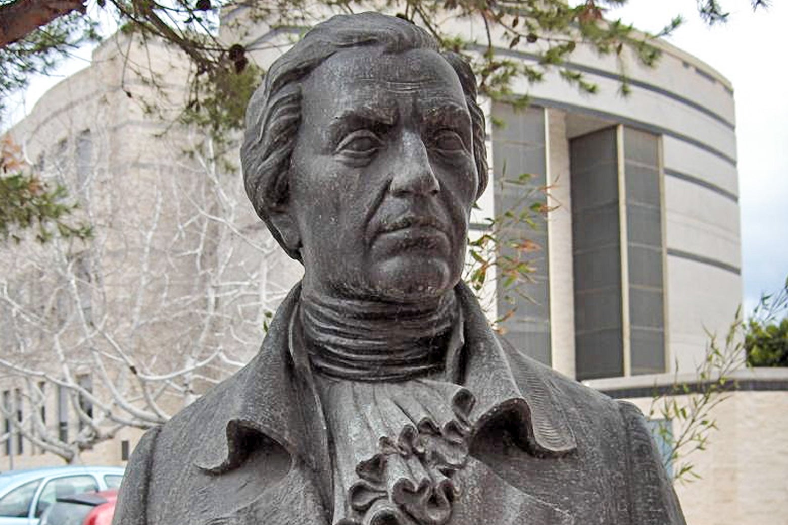 A stone bust of Francisco Javier de Balmis outside a university building