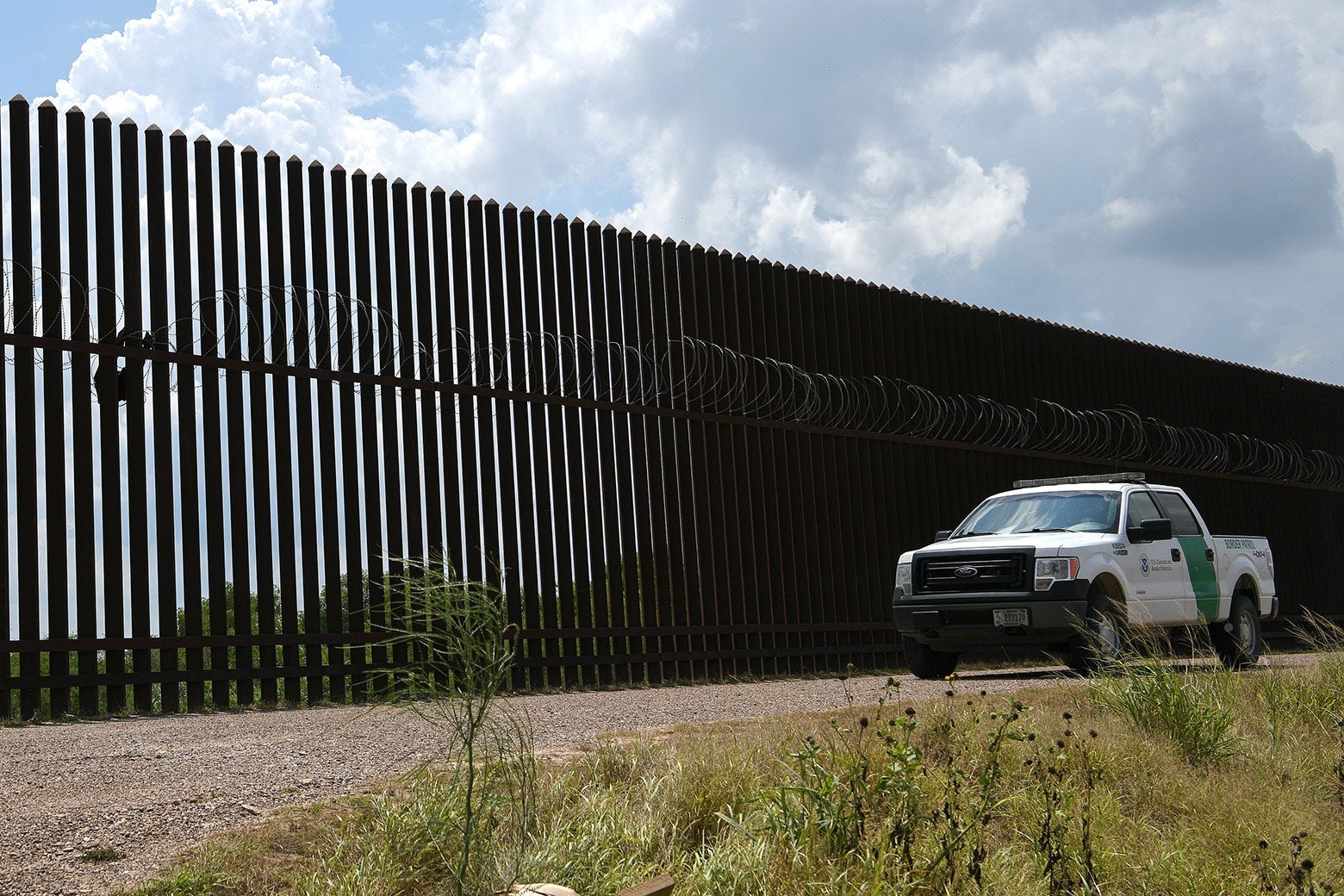 A Border Patrol vehicle drives along a section of border fence near the U.S.-Mexico border on June 12 in Hidalgo, Texas.