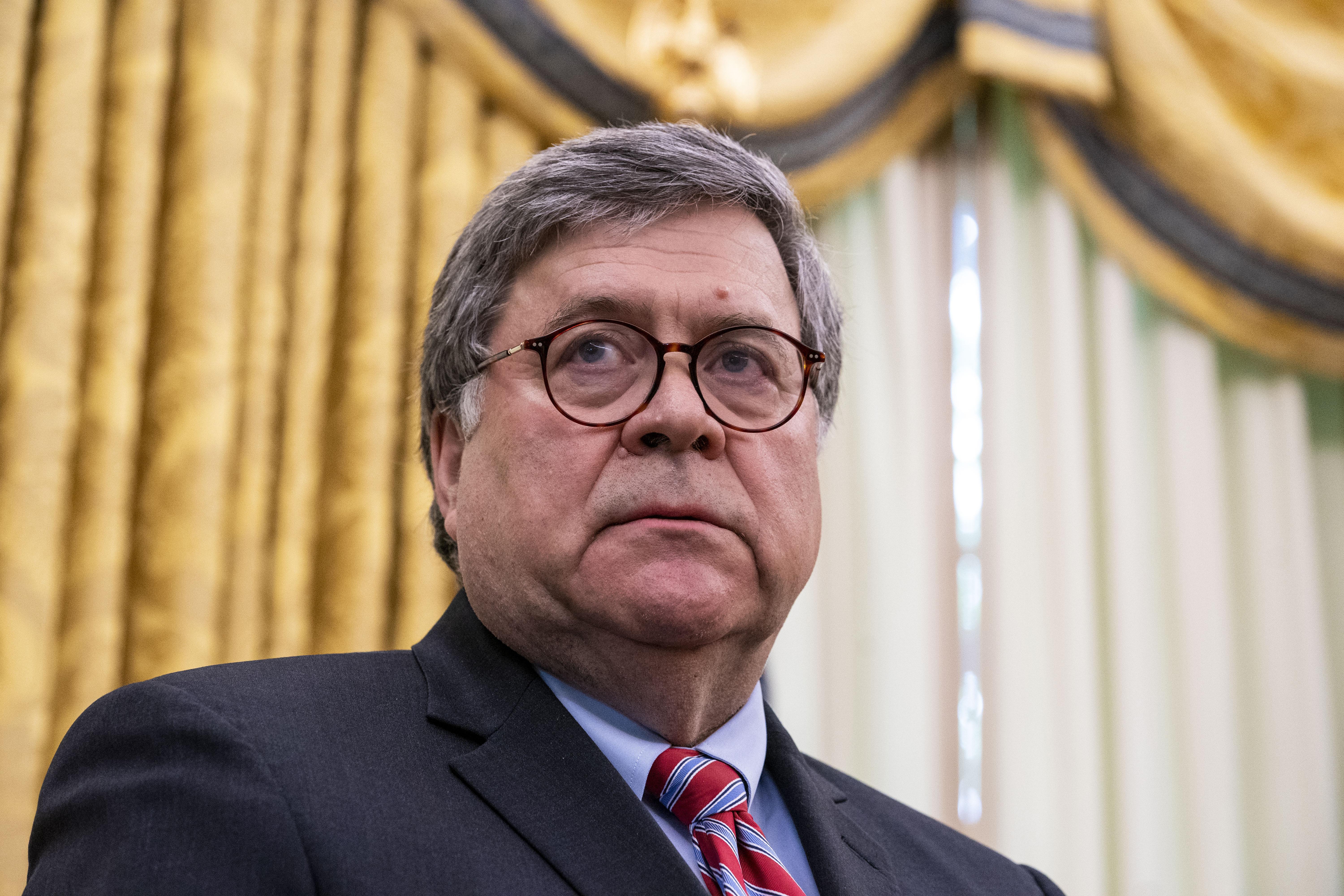 Barr listens as U.S. President Donald Trump speaks in the Oval Office.