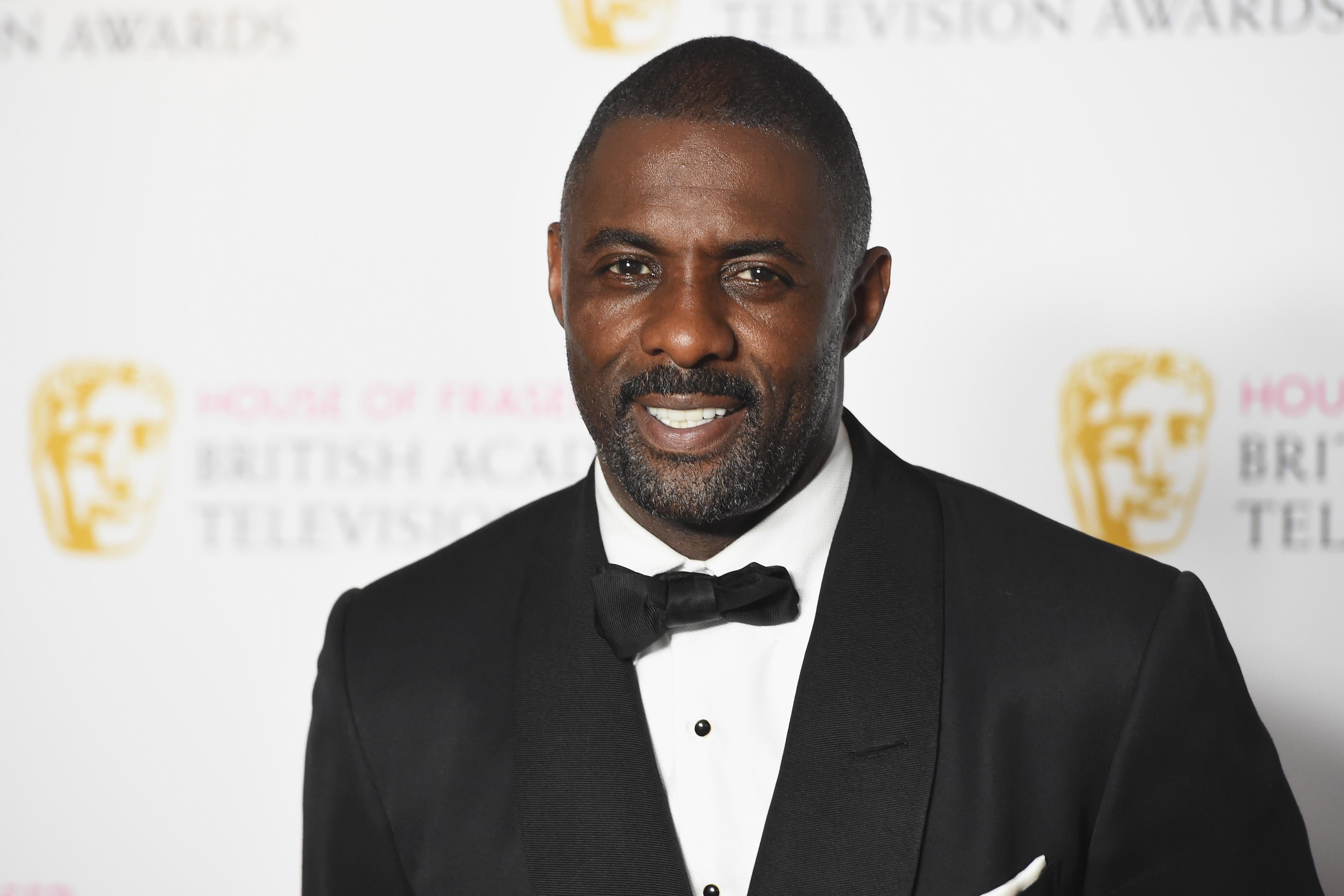 Idris Elba wearing a tux on the BAFTAs red carpet.