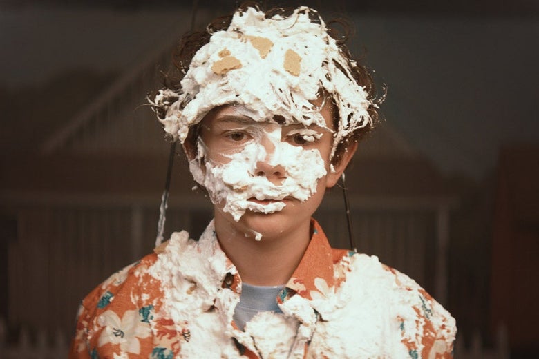 Noah Jupe with whipped cream on his face.