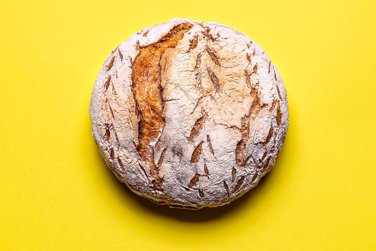 A loaf of leavened bread against a yellow background