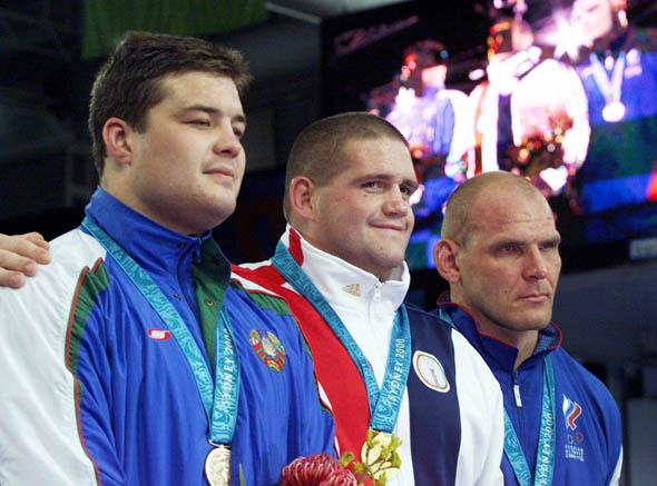 USA's Rulon Gardner (C) stands with his gold medal alongside silver medallist Alexandre Kareline.