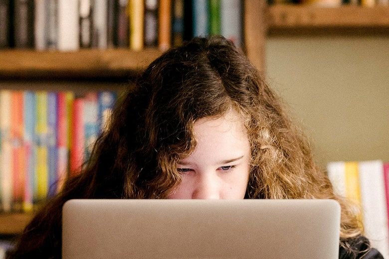 A redhead looks at a laptop.