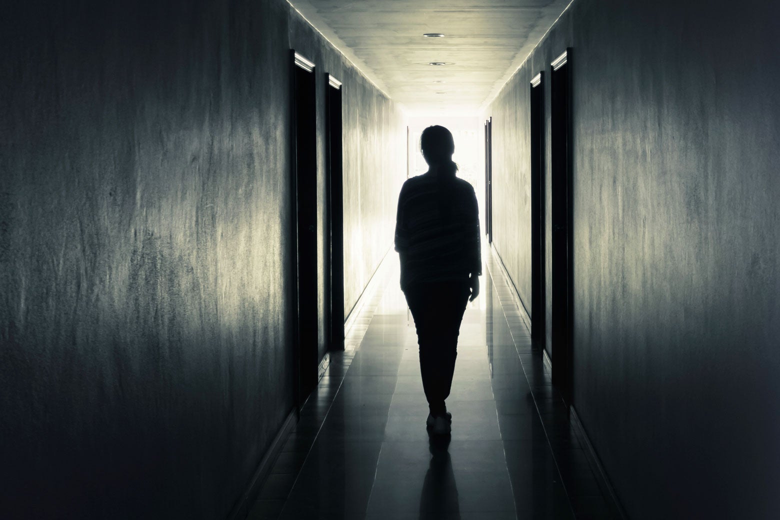 A woman walks down a hallway. 